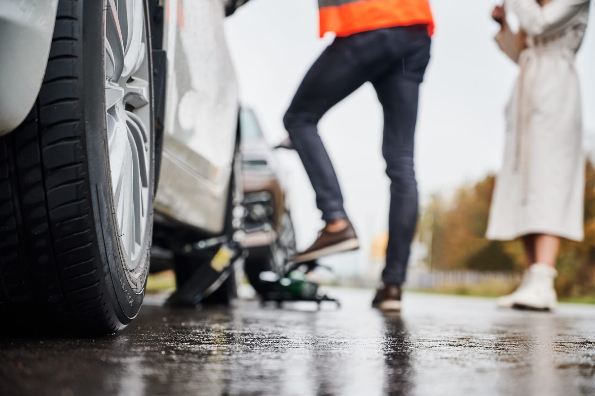 Flat Tires emergency fix auto mechanic repairing woman vehicle on the street.