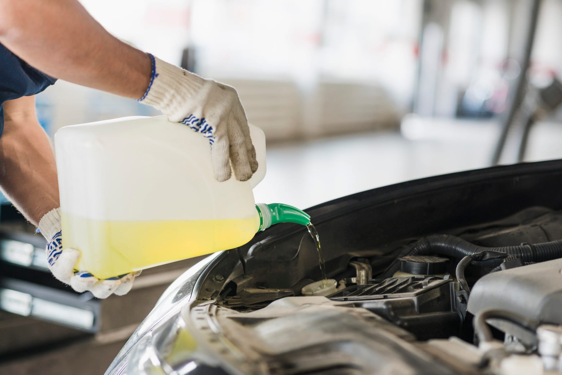 The mechanic is changing oil regularly for the car maintenance